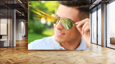 Man wearing sunglasses outdoors, closeup. UVA and UVB rays reflected by lenses, illustration Wall mural