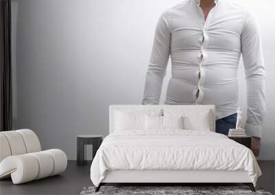 Man wearing tight shirt on white background, closeup. Overweight problem Wall mural