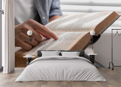 Man with Bible indoors, closeup. Christian faith Wall mural