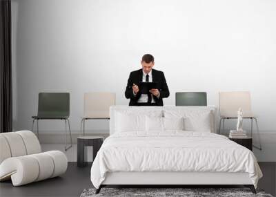 Man with clipboard waiting for job interview in office hall Wall mural