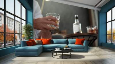 Man with glass of whiskey indoors, closeup view. Space for text Wall mural