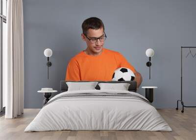 Man with money and soccer ball on grey background Wall mural