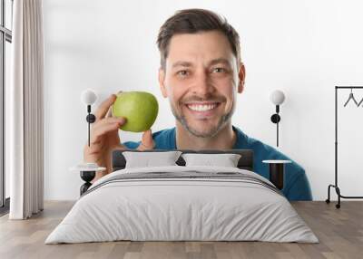 Man with perfect teeth and green apple on white background Wall mural