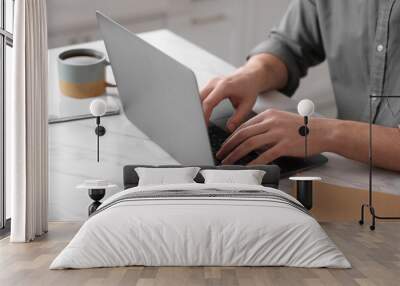 Man working on laptop at white marble table indoors, closeup Wall mural