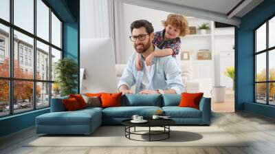 Man working remotely at home. Father with his child at desk Wall mural