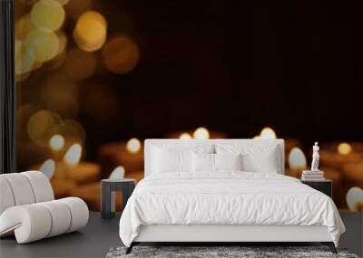 Many burning candles in darkness, bokeh effect Wall mural