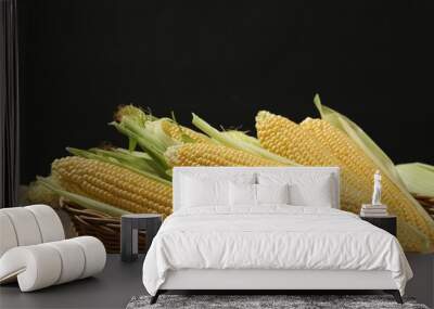 Many fresh ripe corncobs with green husks on wooden table Wall mural