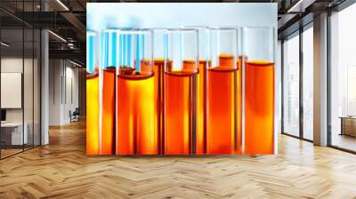 Many test tubes with orange liquid, closeup Wall mural