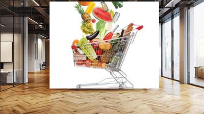 Market assortment. Different products falling into shopping cart on white background Wall mural