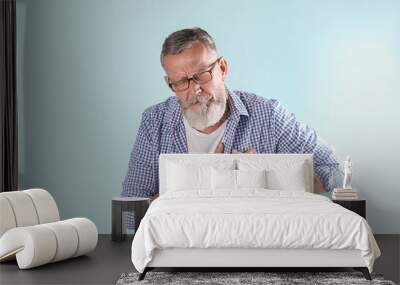 Mature man having heart attack on color background Wall mural