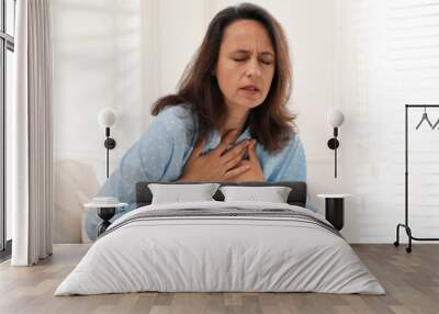 Mature woman suffering from breathing problem at home Wall mural