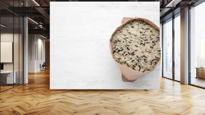 Mix of brown and polished rice in paper bag on white wooden table, top view Wall mural