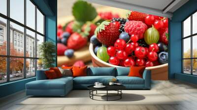 Mix of different fresh berries in bowl on table, closeup Wall mural