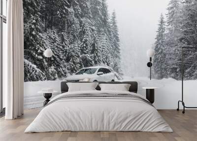 Modern car on snowy road near forest. Winter vacation Wall mural