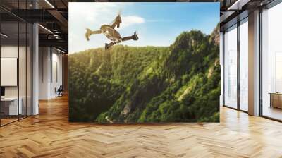 Modern drone flying over picturesque mountains. Aerial survey Wall mural