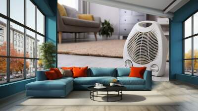 Modern electric fan heater on floor at home. Space for text Wall mural