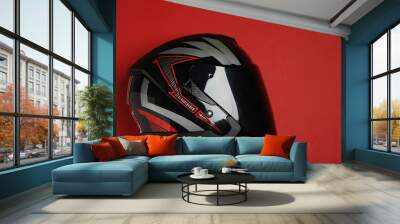 Modern motorcycle helmet with visor on red background, top view. Space for text Wall mural