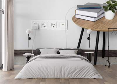 Modern smartphone charging from electric socket indoors Wall mural