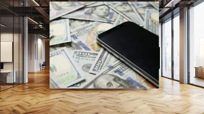 Modern smartphone on dollar bills, closeup view Wall mural