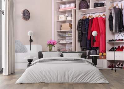 Modern wardrobe with stylish clothes in room interior Wall mural