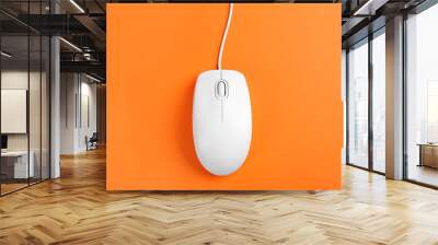 Modern wired optical mouse on orange background, top view Wall mural