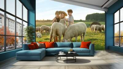 mother and children stroking sheep on pasture. farm animals Wall mural