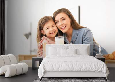 Mother and daughter having breakfast with milk at table Wall mural