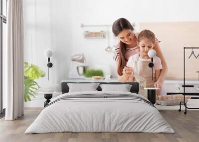 Mother and her daughter making dough at table in kitchen Wall mural