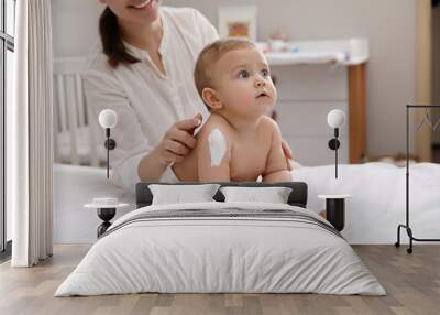 Mother applying moisturizing cream on her little baby at home, closeup Wall mural