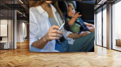 Mother with cigarette and child in car, closeup. Don't smoke near kids Wall mural