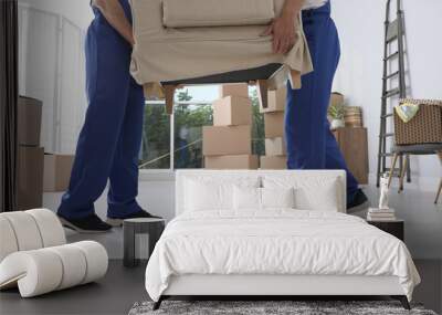 Moving service employees carrying armchair in room, closeup Wall mural