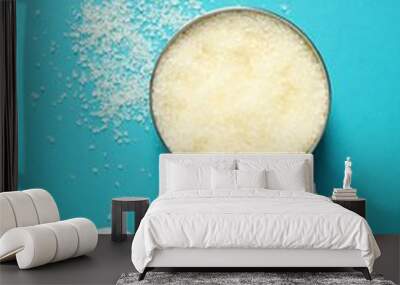 Natural sea salt in bowl, chamomile and petals on light blue background, flat lay Wall mural