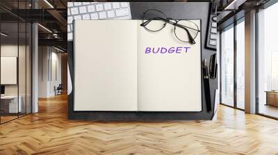 Notebook with word Budget, calculator, glasses, keyboard and mouse on dark table, flat lay Wall mural