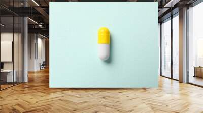 One colorful pill on mint background, top view Wall mural