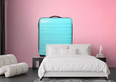 One new turquoise suitcase on pink background Wall mural