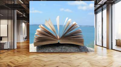 Open book near sea on summer day Wall mural