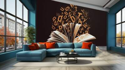 Open book with flying letters on wooden table against brown background. Dyslexia concept Wall mural