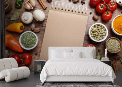 Open recipe book and different ingredients on wooden table, flat lay. Space for text Wall mural