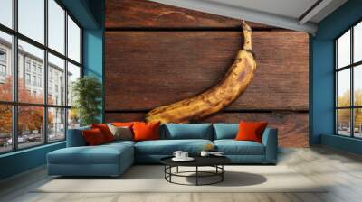 Overripe banana with dark spots on white wooden table, top view Wall mural