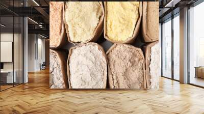 Paper sacks with different types of flour as background, closeup Wall mural