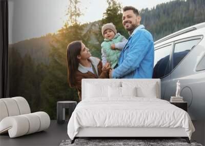 Parents and their daughter near car in mountains. Family traveling Wall mural