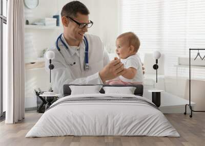 Pediatrician examining cute little baby in clinic. Space for text Wall mural