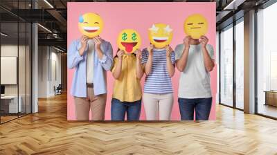 People covering faces with emoticons on pink background Wall mural