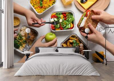 People with lunchboxes at white wooden table, top view. Healthy food delivery Wall mural