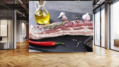 Piece of raw pork belly, rosemary, chili pepper and spices on grey table Wall mural