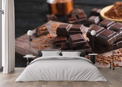 Pieces of black chocolate on wooden board Wall mural