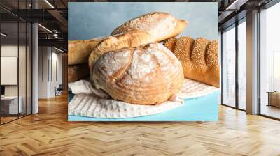 Pile of fresh bread on table against color background, closeup Wall mural