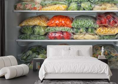 Plastic bags with different frozen vegetables in refrigerator Wall mural