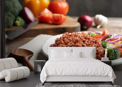 Plate of boiled brown rice with vegetables served on table, closeup. Space for text Wall mural