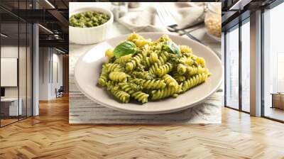 Plate with delicious basil pesto pasta on wooden table Wall mural